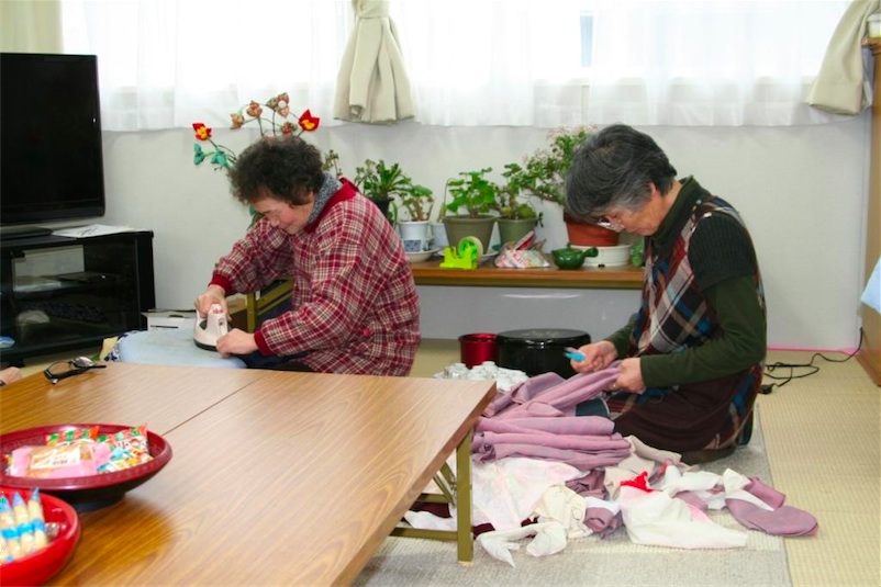 出島の仮設住宅で内職をする女性